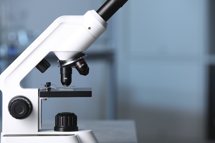 Modern medical microscope against blurred background, closeup.