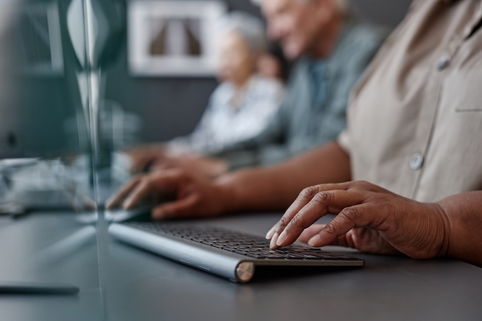 Closeup of elderly black woman typing on keyboard